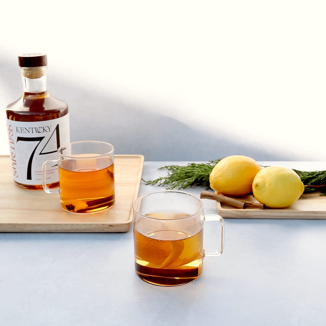 Non-alcoholic hot toddy in glass mugs with Spiritless Kentucky 74 and lemons