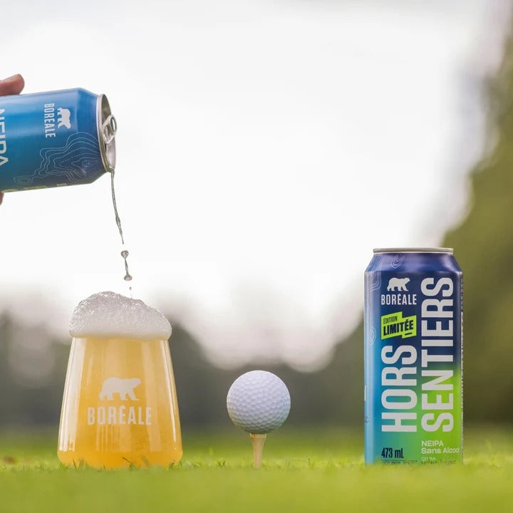 Boréale Hors Sentiers NEIPA sans alcool versée dans un verre sur un terrain de golf